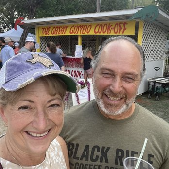 Festival guests smiling in front of the Great Gumbo Cook-Off booth