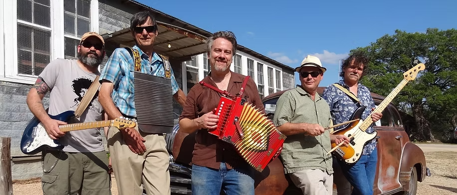 Zydeco Blanco posing with instruments including accordion and rubboard